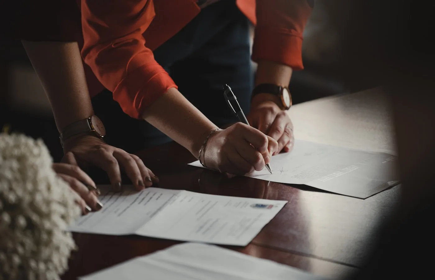 Person signing a formal document with pen